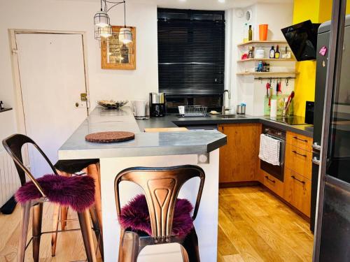 - une cuisine avec un comptoir et quelques chaises dans l'établissement Triplex au cœur de Bayonne, 4 couchages, Internet inclus - FR-1-495-150, à Bayonne