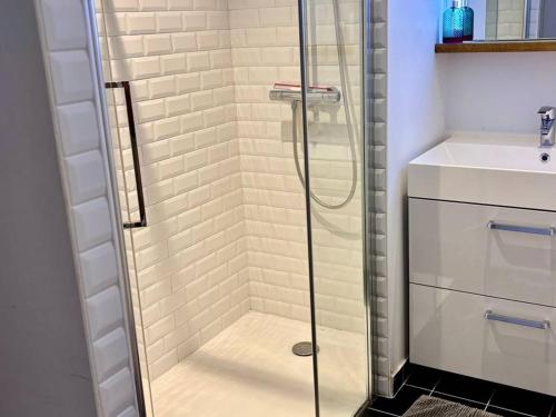 une douche en verre dans une salle de bain avec un lavabo dans l'établissement Triplex au cœur de Bayonne, 4 couchages, Internet inclus - FR-1-495-150, à Bayonne