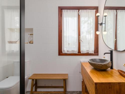a bathroom with a bowl sink and a mirror at Preciosa y amplia casa con piscina in Liendo