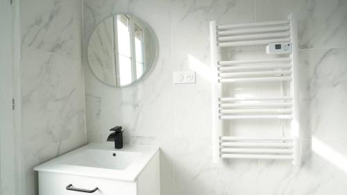 a white bathroom with a sink and a mirror at Bel appartement - Paris Choisy Orly - Jardin in Choisy-le-Roi