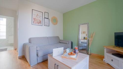 a living room with a couch and a table at Bel appartement - Paris Choisy Orly - Jardin in Choisy-le-Roi