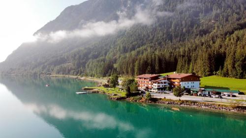 ein Dorf am Ufer eines Flusses mit einem Berg in der Unterkunft Seehotel St Hubertus in Pertisau