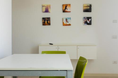 a white table and chairs with pictures on the wall at Boomerang Village in Torre Colimena