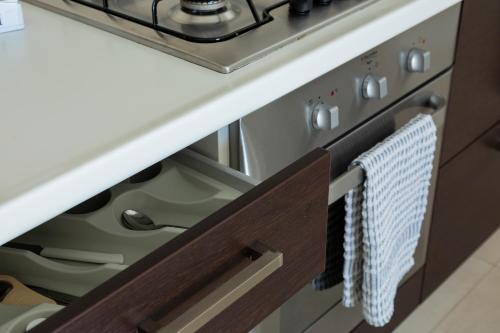 a kitchen drawer with a towel hanging on the oven door at Boomerang Village in Torre Colimena