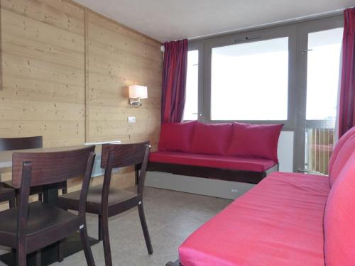 un salon avec un canapé rouge et une table dans l'établissement travelski home select - Vue Mont Blanc, à Aime La Plagne