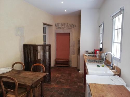 d'une cuisine avec une table, un évier, une table et un sidx de table. dans l'établissement Les Tomettes, à Dole