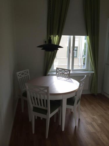 a white table and chairs in a room with a window at Min Pärla in Östersund
