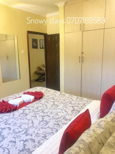a bedroom with a large bed with red pillows at Snowy stays in Eldoret