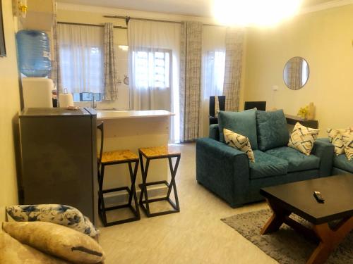 a living room with a couch and a kitchen at Snowy stays in Eldoret