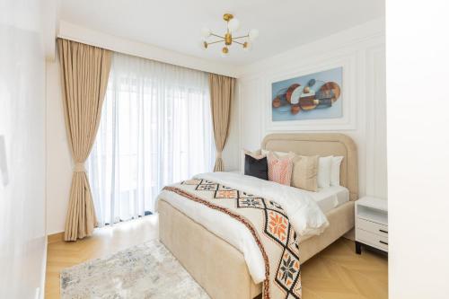 a white bedroom with a large bed and a window at TheEJResidence- 2Bedroom All Ensuite- 7km from JKIA 3km from SGR and Expressway along Mombasa Road-Nairobi Kenya in Nairobi