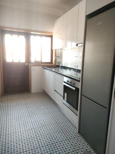 a kitchen with white cabinets and a black and white floor at SOL & SAL T2 Matosinhos in Matosinhos