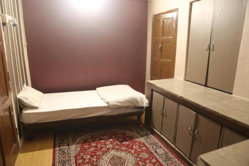 a small room with a bed and a mirror at Vedic Dham Ganga in Rishīkesh