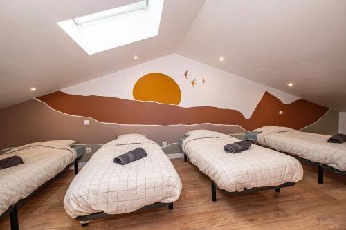 four beds in a room with a mural on the wall at Gîte des Roussèles - Climatisation, Spa, jardin in Gaillac