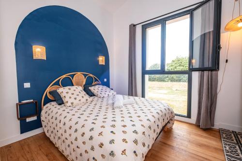 a blue bedroom with a bed and a large window at Gîte des Roussèles - Climatisation, Spa, jardin in Gaillac