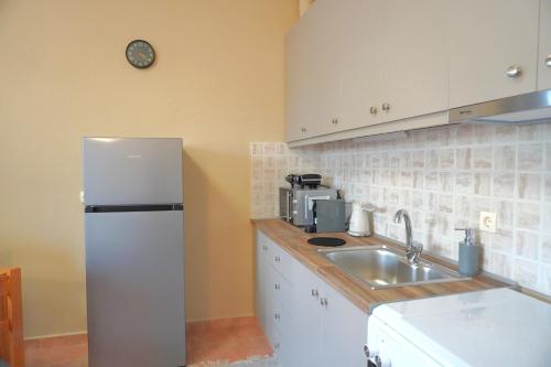 a kitchen with a white refrigerator and a sink at Papadakis Family Home - 1 BR apartment in Asopós