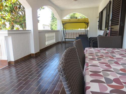 uma sala de jantar com uma mesa e cadeiras e duas janelas em Apartments Gloria em Biograd na Moru