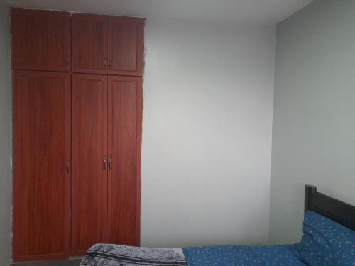 a bedroom with a bed and a wooden cabinet at City View Apartment, Albert Cook Road in Kampala