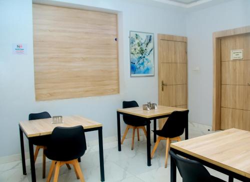 a dining room with two tables and chairs at Caritas Inn, Ilasan in Lagos