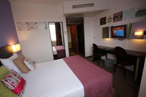 a hotel room with a bed and a desk at Hotel Floris Arlequin Grand-Place in Brussels
