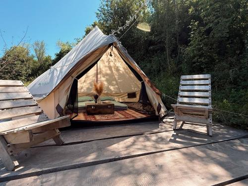 a canvas tent with a chair and a chair at Comfortable camping on Family Soap Farm in Ryskulovo