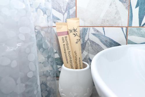 a vase with two toothbrushes in it next to a toilet at Tesaran Stepanavan Guest House, Apart Hotel in Stepʼanavan
