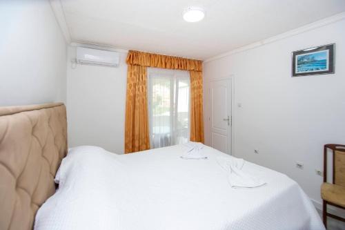 a bedroom with a white bed and a window at Rama Residence in Budva