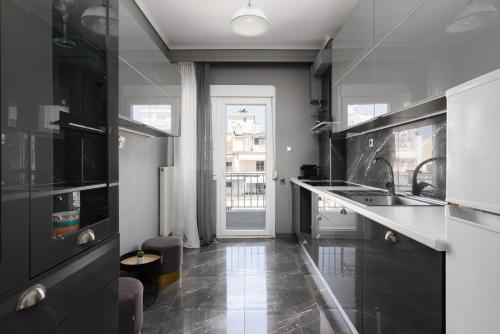 a kitchen with black counters and a sink and a window at Houseloft Cityscape Bliss in Thessaloniki