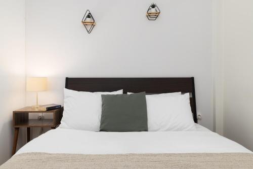 a bedroom with a white bed with a black headboard at Houseloft Cityscape Bliss in Thessaloniki