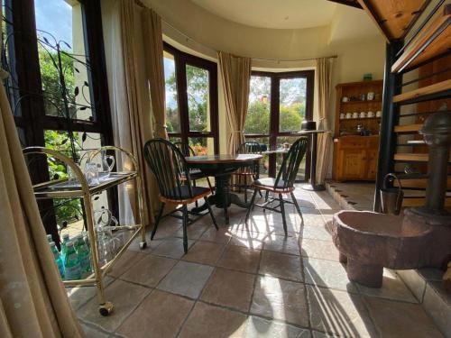 a room with a table and chairs and windows at Private Stay in Scenic Home, near Portrush in Portstewart