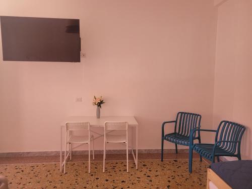 a white table with two chairs and a vase with flowers at Sea Lily in Lido di Ostia