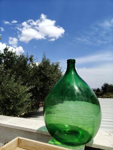 a green glass vase sitting in a wooden box at Vittò in Martina Franca