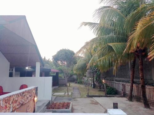 a view of a house with palm trees in the yard at Barrel lodge in Kuta Lombok
