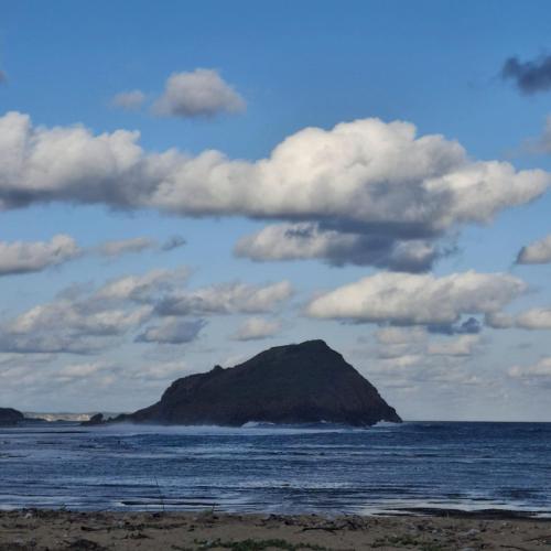 a small island in the ocean under a cloudy sky at Barrel lodge in Kuta Lombok