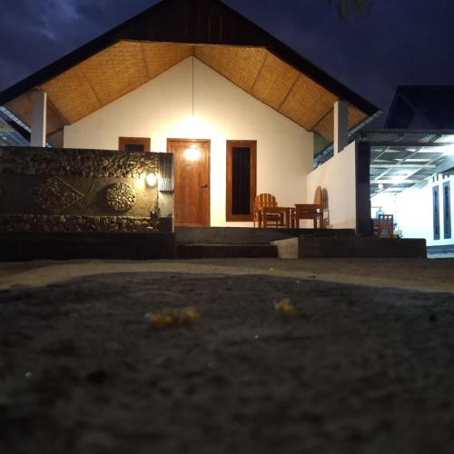 a small white house with a table and chairs at Barrel lodge in Kuta Lombok