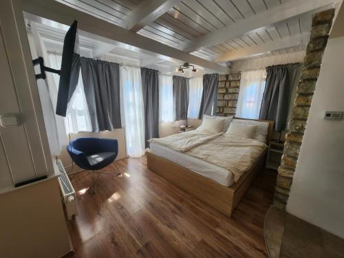 a bedroom with a bed and a chair and windows at Lake Horizon in Balatonfüred