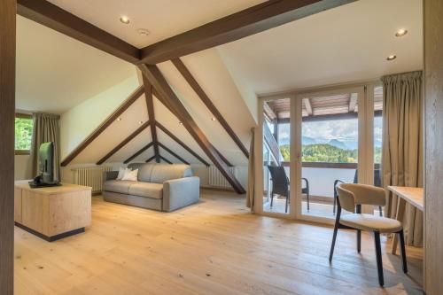 a living room with a couch and a table with a television at Hotel am Hang in Soprabolzano