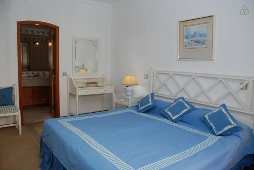 a blue bed with blue pillows in a bedroom at Genies Villa Boutique Algarve in Almancil