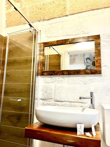 a bathroom with a white sink and a mirror at Kamelia Loft in Polignano a Mare