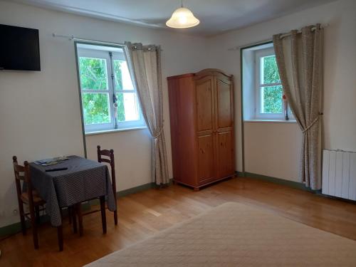 a living room with a table and two windows at Les Cigales in Charols