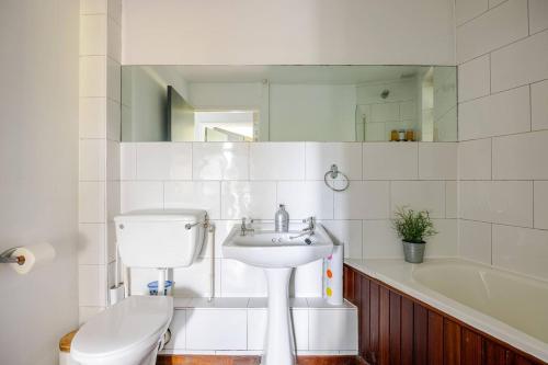 un bagno con lavandino, WC e vasca di Charming Summerhouse Annexe in lush gardens in Fowey a Fowey