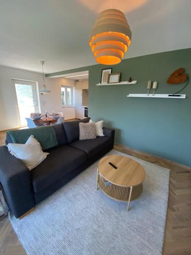 a living room with a blue couch and a table at Moderne Ferienwohnung mit Garten in Spalt