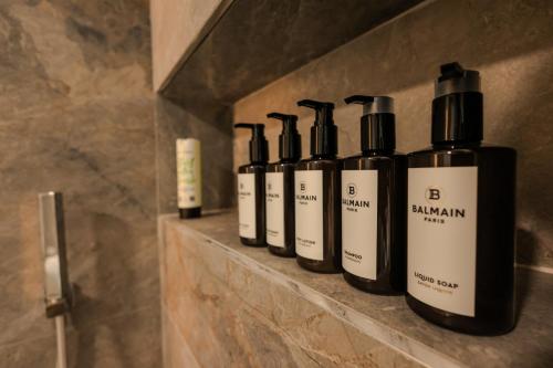 a row of bottles sitting on a shelf in a bathroom at SanPietro Premium Villas in Draçi