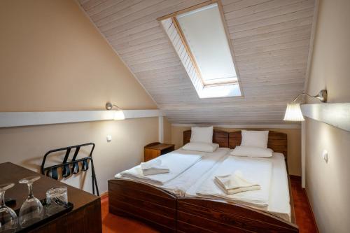 a attic bedroom with a bed with a skylight at Renegade Hotel in Siófok