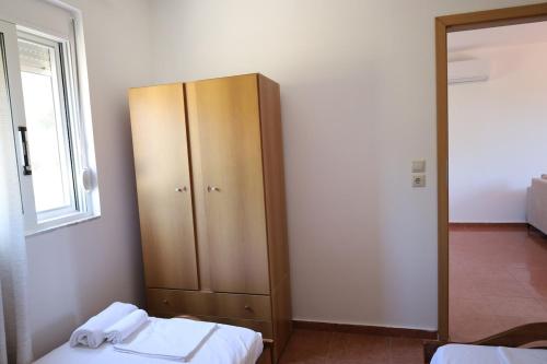 a bedroom with a cabinet and a bed and a window at Kritharistra Home in Vlakhiá