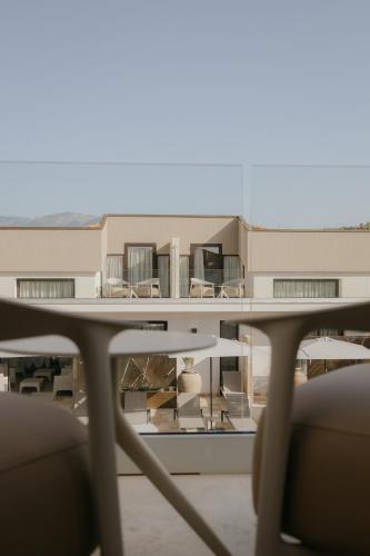 a table with chairs in front of a building at Palmar Boutique Hotel in Campofelice di Roccella