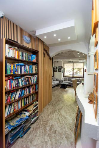 a library with wooden book shelves filled with books at Rama Residence in Budva