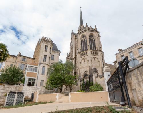 an old church with a steeple in a city at Hôtel des Arts in Angoulême