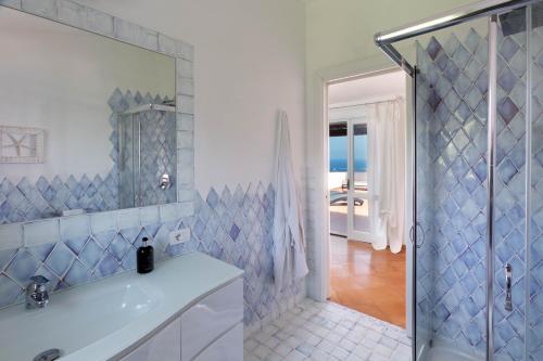 a white bathroom with a shower and a sink at Villa Azzurra con vista mozzafiato in Porto Cervo
