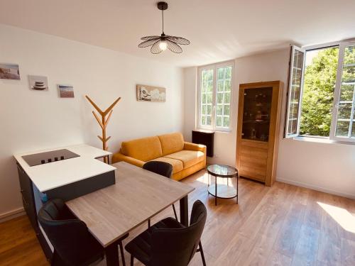 a living room with a table and a couch at Le Nid des Charmettes in Saint-Josse