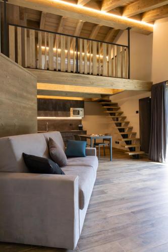 a living room with a couch and a staircase at Lillaz Home - Apartments in Cogne